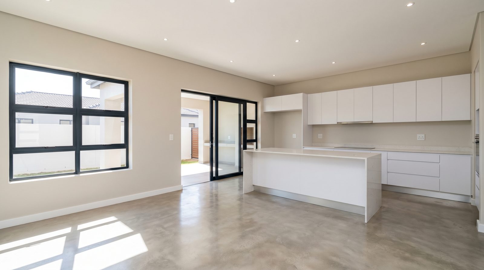 An empty open-plan dining area next to a kitchen in a South African home